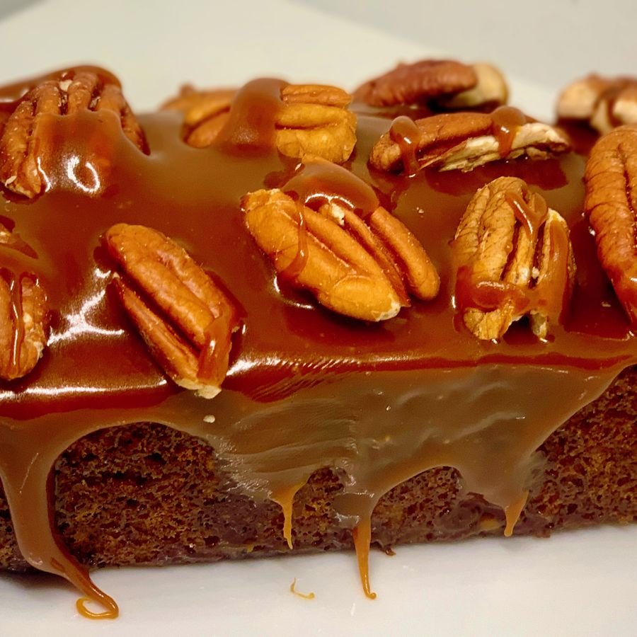 A loaf topped with whole pecans and caramel